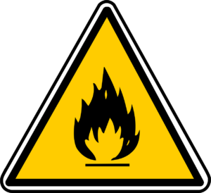 A yellow warning sign with the symbol of fiery flames in the center, symbolizing the inflammation that occurs when we fail to address the fact that "Less Grief = Better Health."