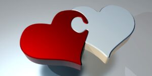 A red and a white heart as connected puzzle pieces - for Caregiver Advice From My Heart to Yours