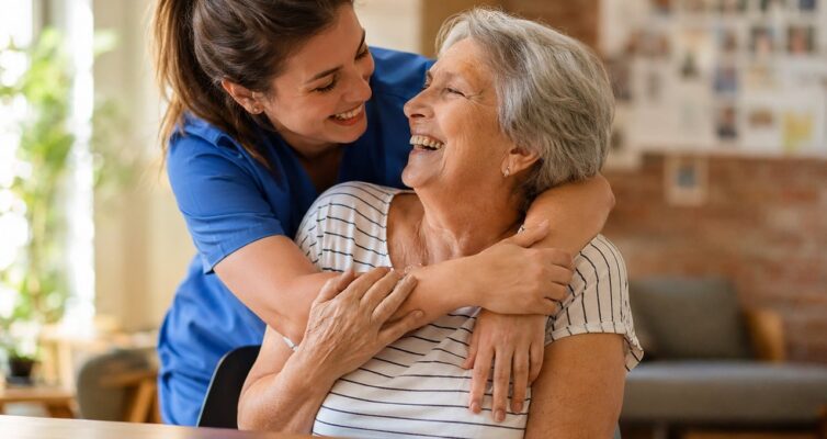 Caregiver helping Woman with writing. A daughter can do this with a Personal Care Agreement if the family can pay for the services.